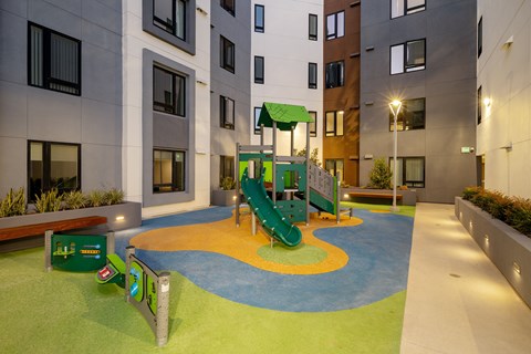 A playground area with a slide and a green canopy.