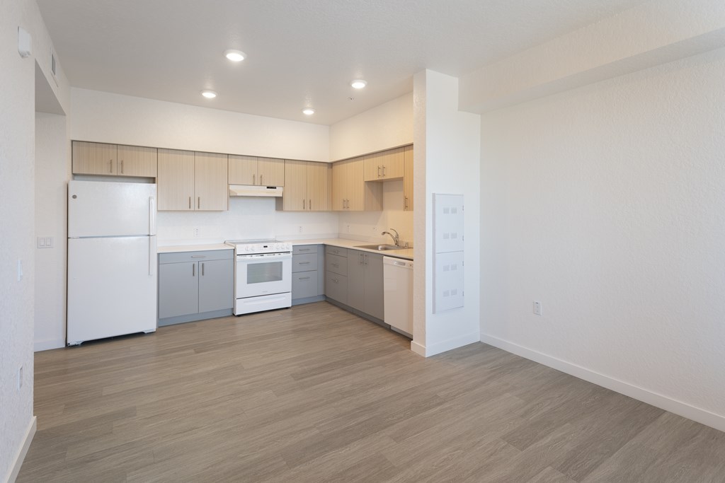 A kitchen with white appliances and wooden cabinets.