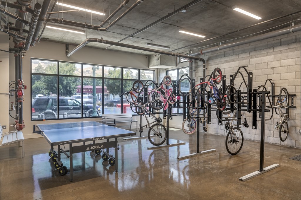 A room with a table, chairs, and bicycles.