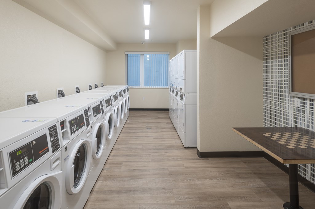 A laundry room with washing machines and a counter.