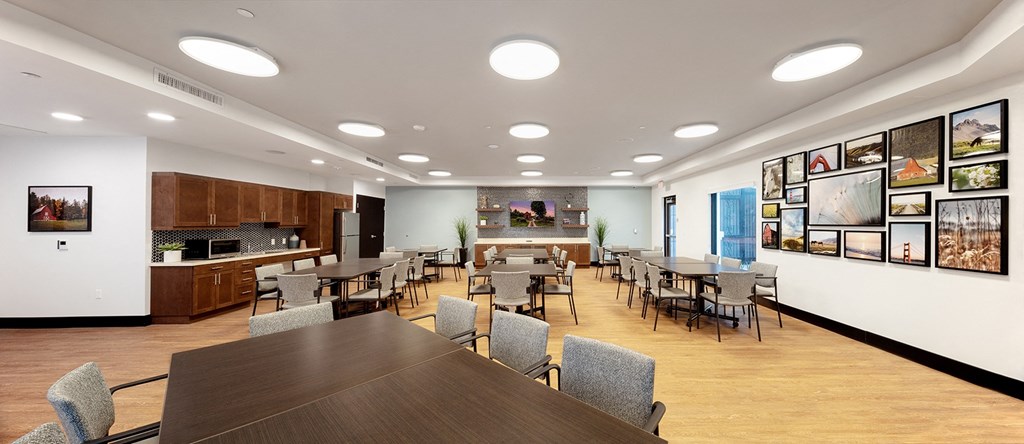 a dining room with tables and chairs and a kitchen