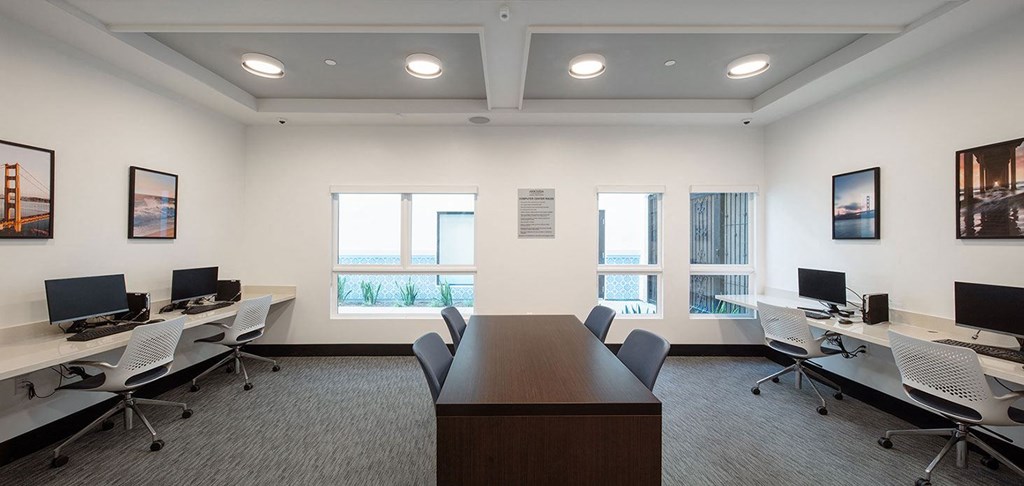 a conference room with desks and chairs and monitors