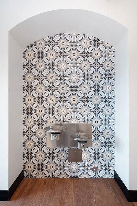 a bathroom with a toilet and tiles on the wall