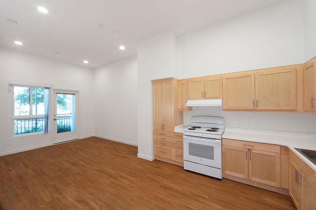 an empty kitchen with wooden cabinets and a white stove