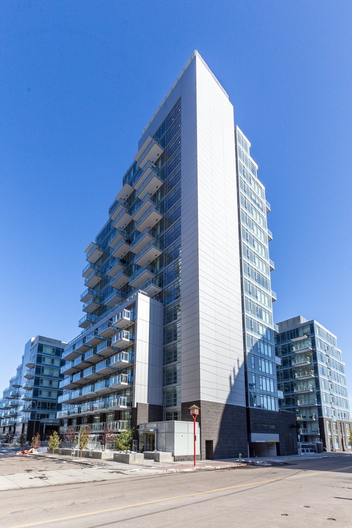 A tall, modern building with a white facade stands in the foreground.