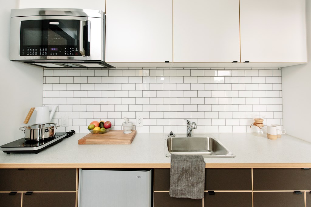 A modern kitchen with a microwave, sink, and refrigerator.