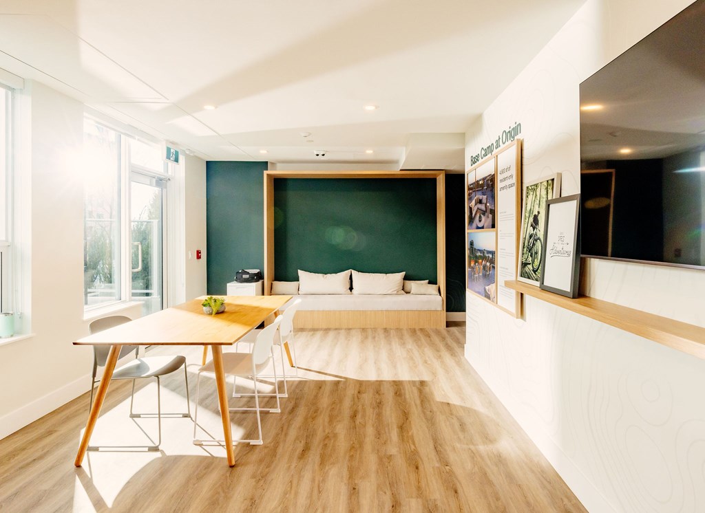 A room with a bed, a table and chairs.