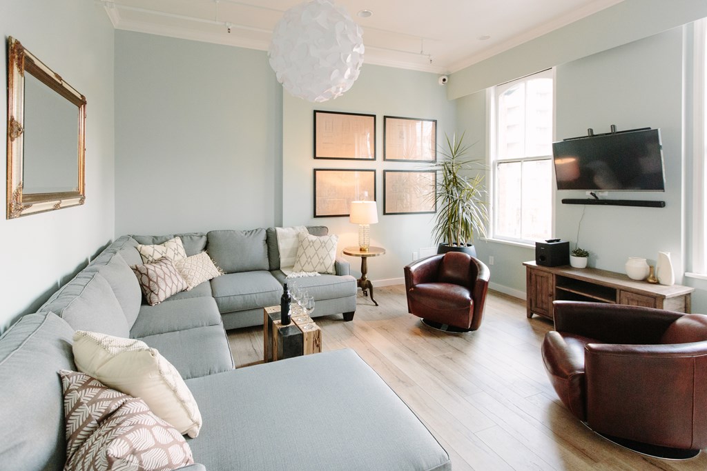 A living room with a grey sofa and brown leather chairs.