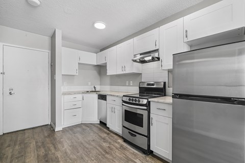 A kitchen with white cabinets and appliances.