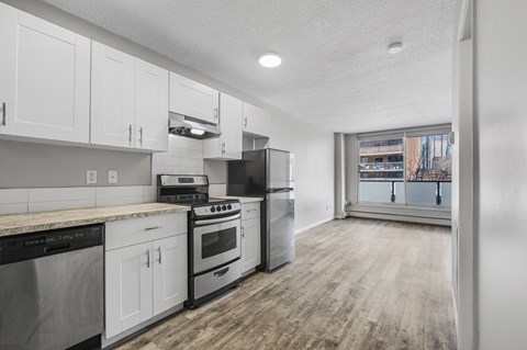 A kitchen with white cabinets and stainless steel appliances.