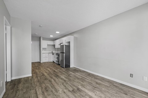 A kitchen with white cabinets and a wooden floor.