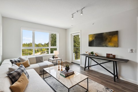 A modern living room with a large window overlooking a green landscape.