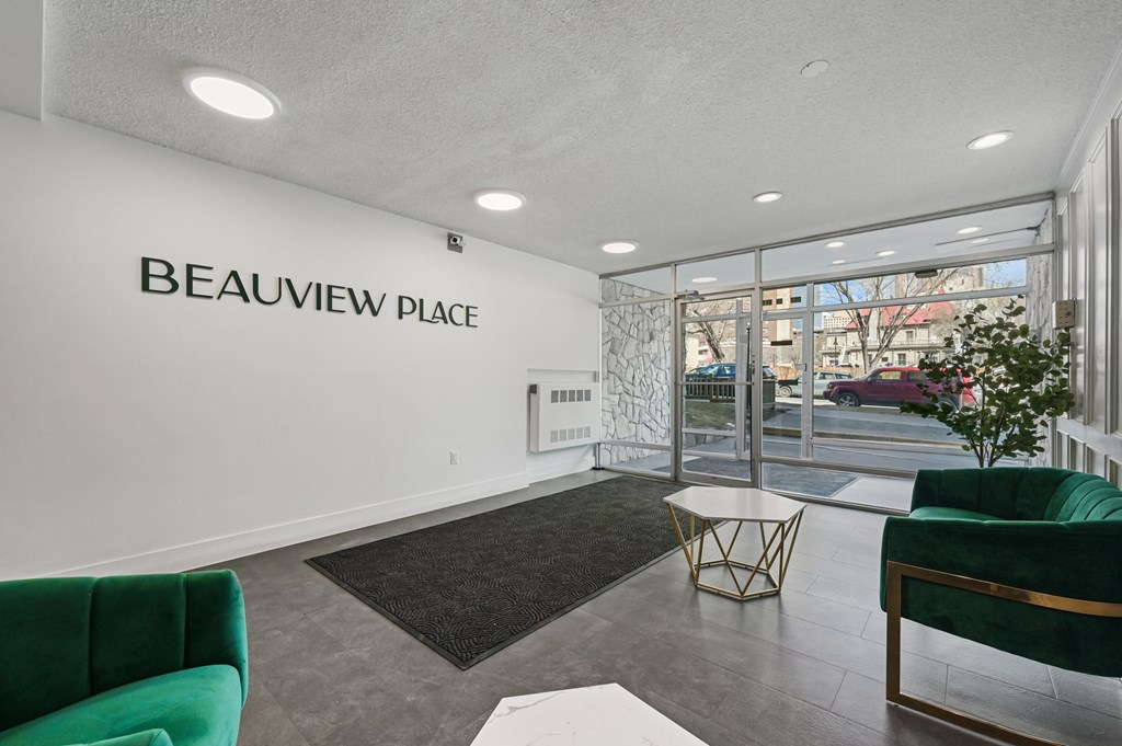 A waiting area with a green couch and a sign that says Beauview Place.