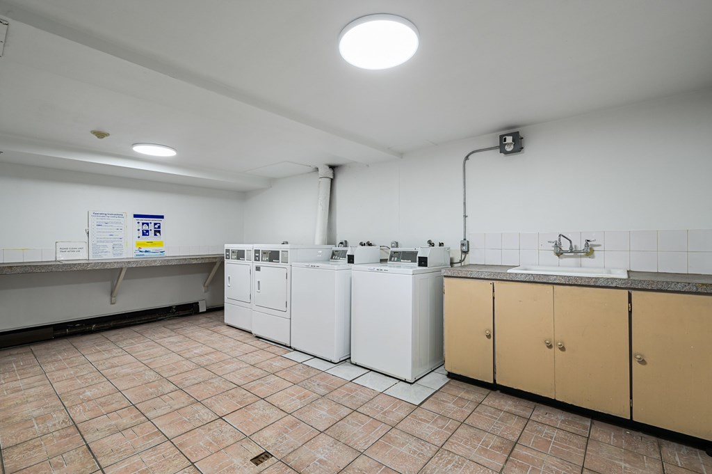 A kitchen with white appliances and brown cabinets.