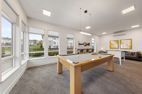 A room with a pool table and a couch.