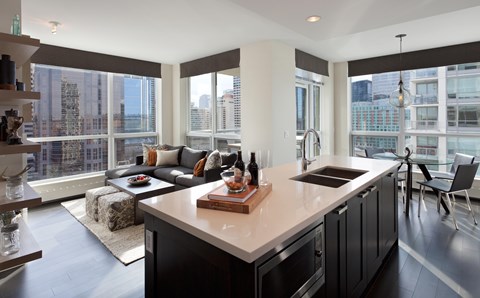 A modern kitchen with a large island and a view of the city.