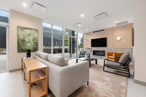 A modern living room with a grey sofa, a wooden table, and a television.