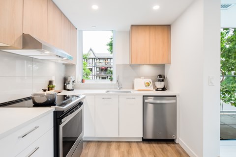 A modern kitchen with white cabinets and a stainless steel dishwasher.