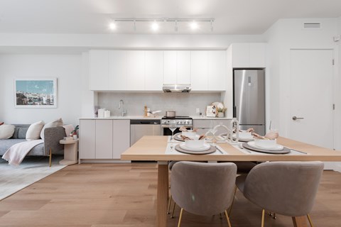 A modern kitchen with a dining table set for two.