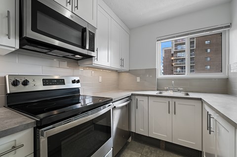 A modern kitchen with a stove top oven and microwave above it.