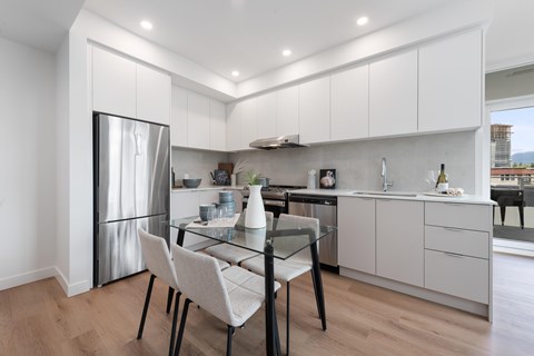 A modern kitchen with a glass table and chairs.