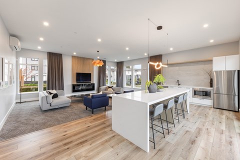 A modern kitchen with a bar and seating area.