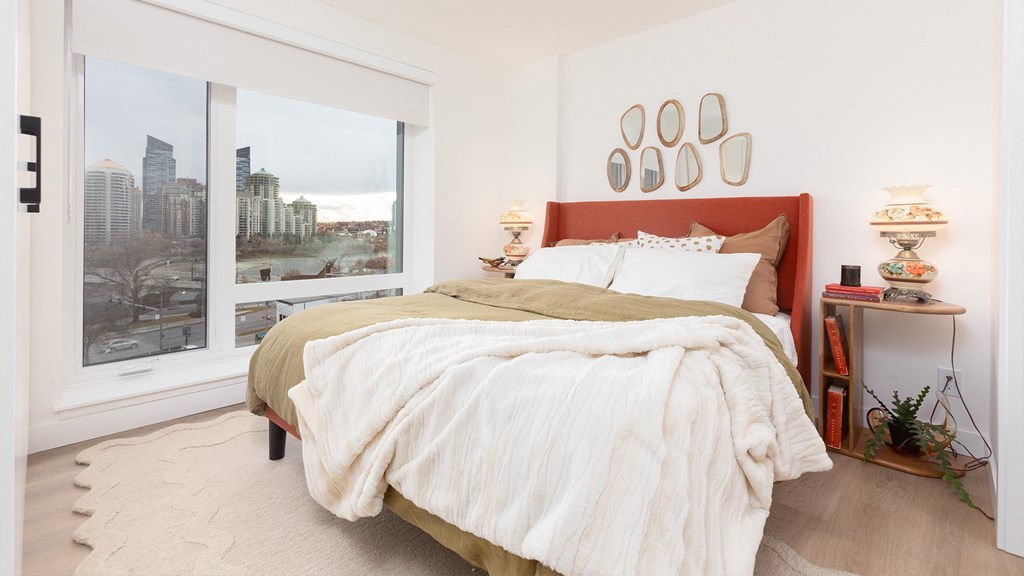 a bedroom with a bed and a large window