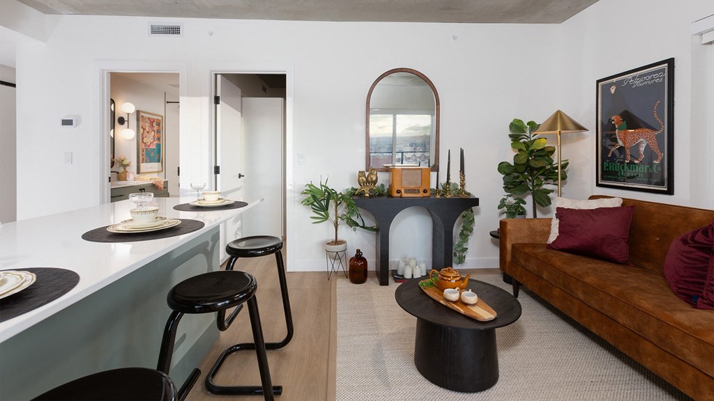a living room with a fireplace and a bar with stools