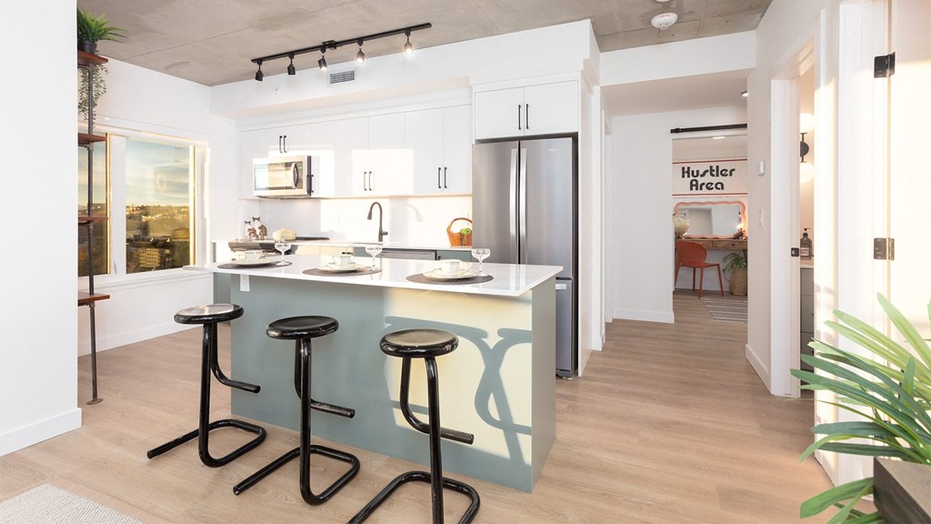 a kitchen with a counter and three stools