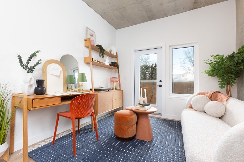 a living room with a desk with a chair and a couch
