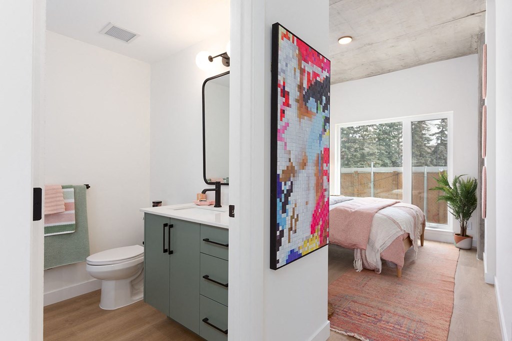 a bathroom with a toilet and a sink and a bed