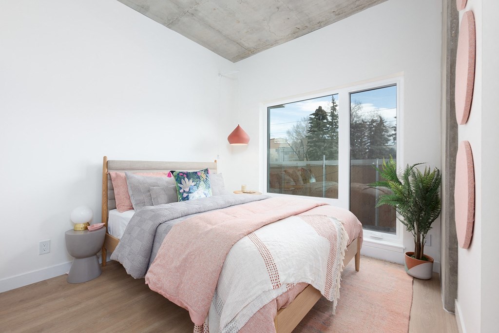 a bedroom with a bed and a large window