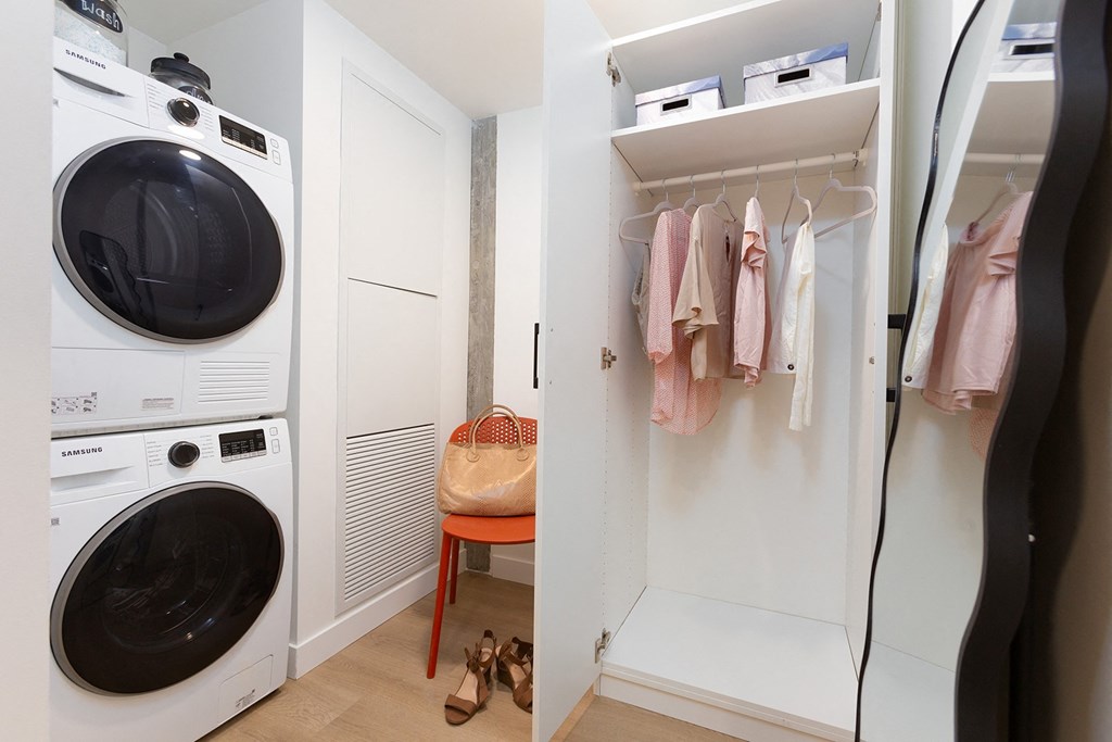 a laundry room with pink and purple wallpaper and a washing machine