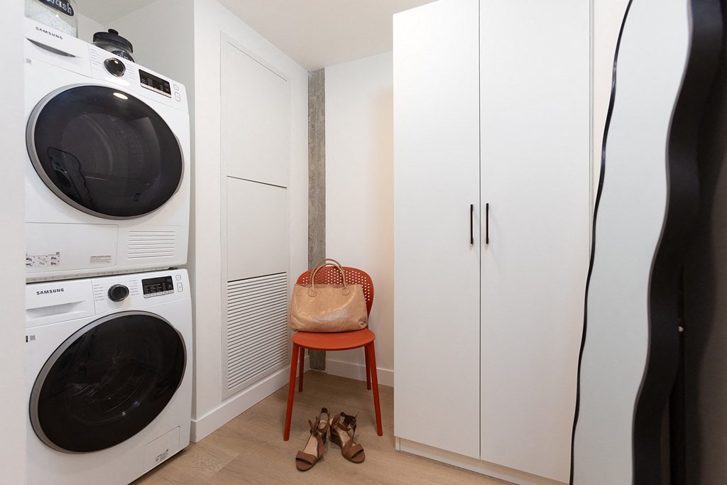a small laundry room with a washing machine and a wardrobe