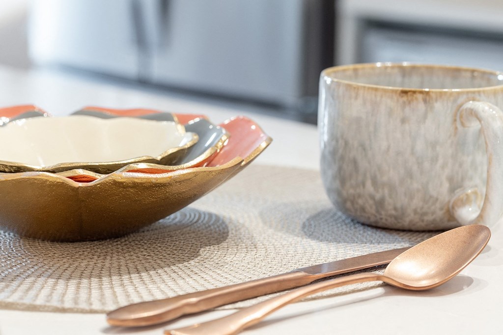 a table set with a bowl and a cup and utensils