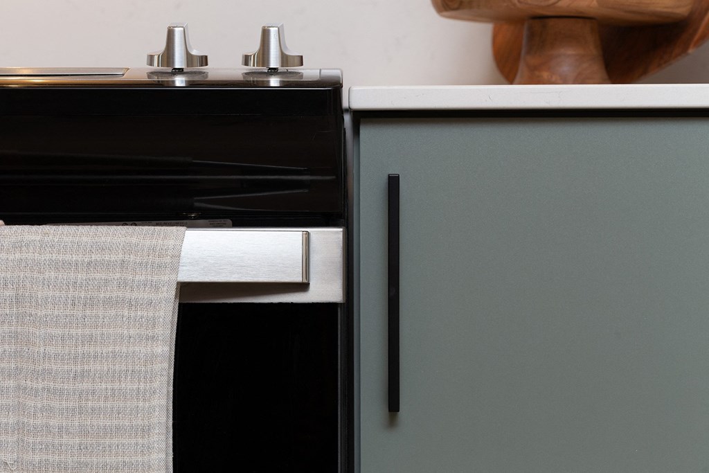 a kitchen with an oven and a cabinet with a towel on it