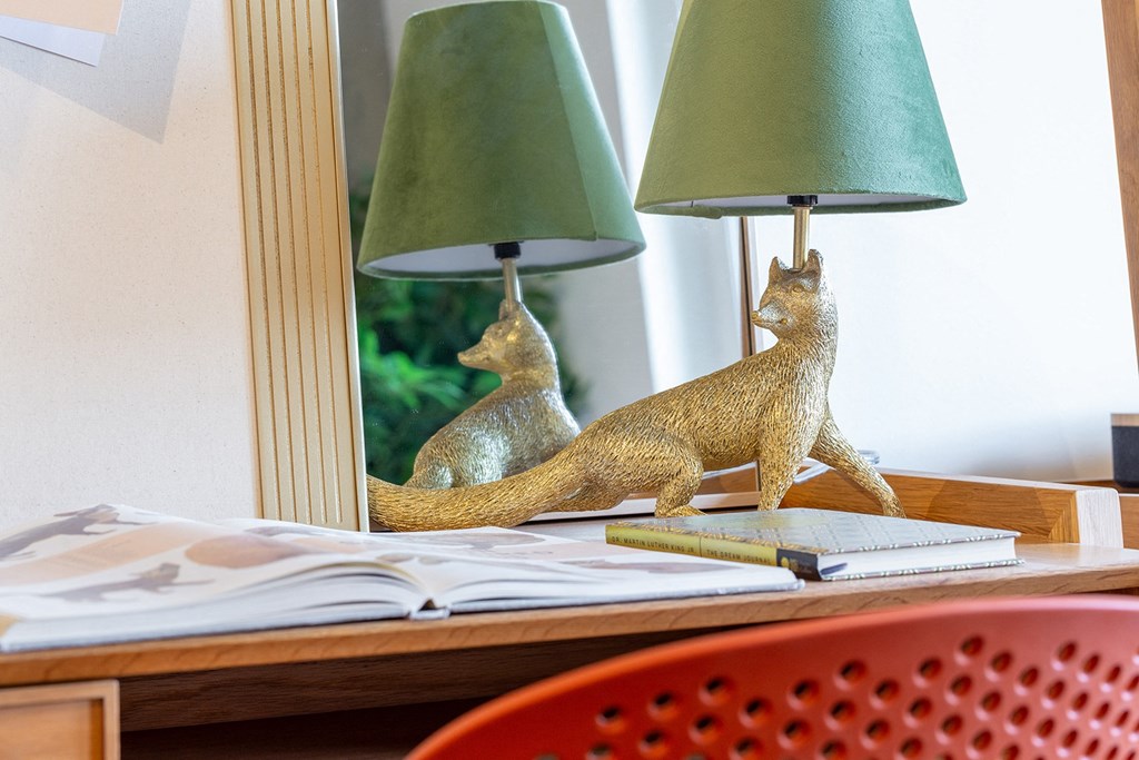 a desk with two lamps and a mirror with two squirrels on it