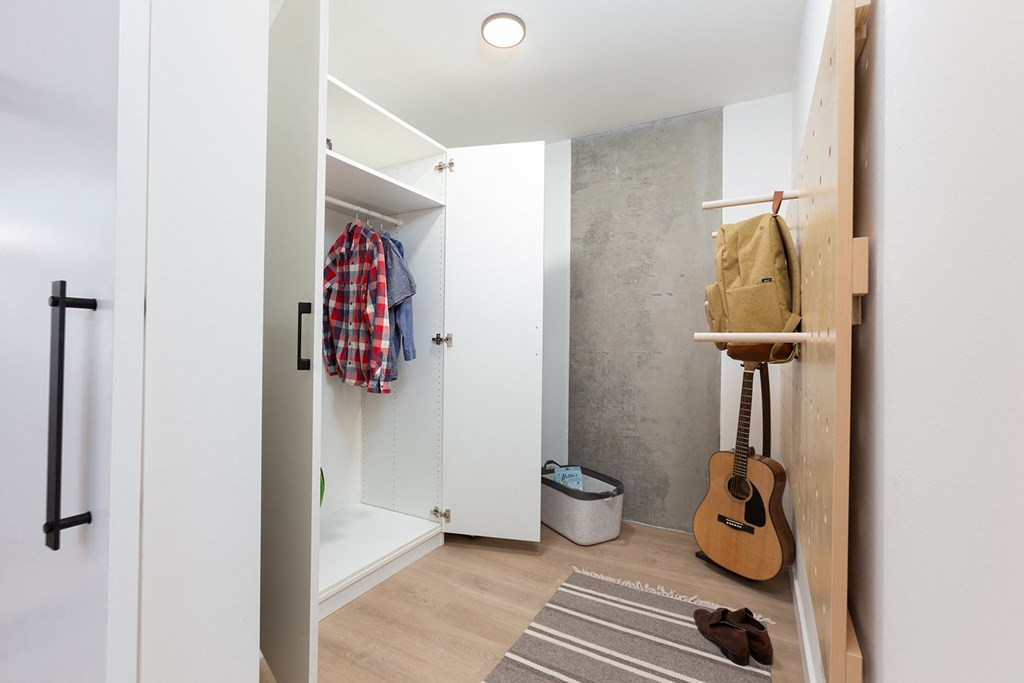 a small bathroom with a closet and a guitar on the wall