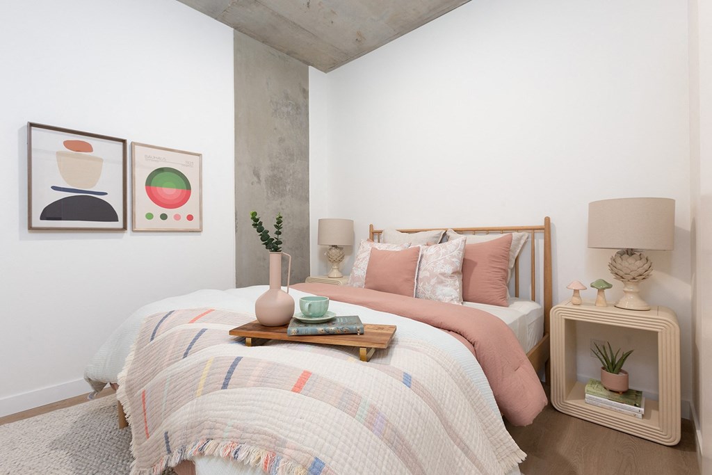 a bedroom with a bed and two paintings on the wall