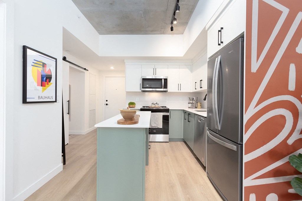a kitchen with white cabinets and stainless steel appliances and a white counter top