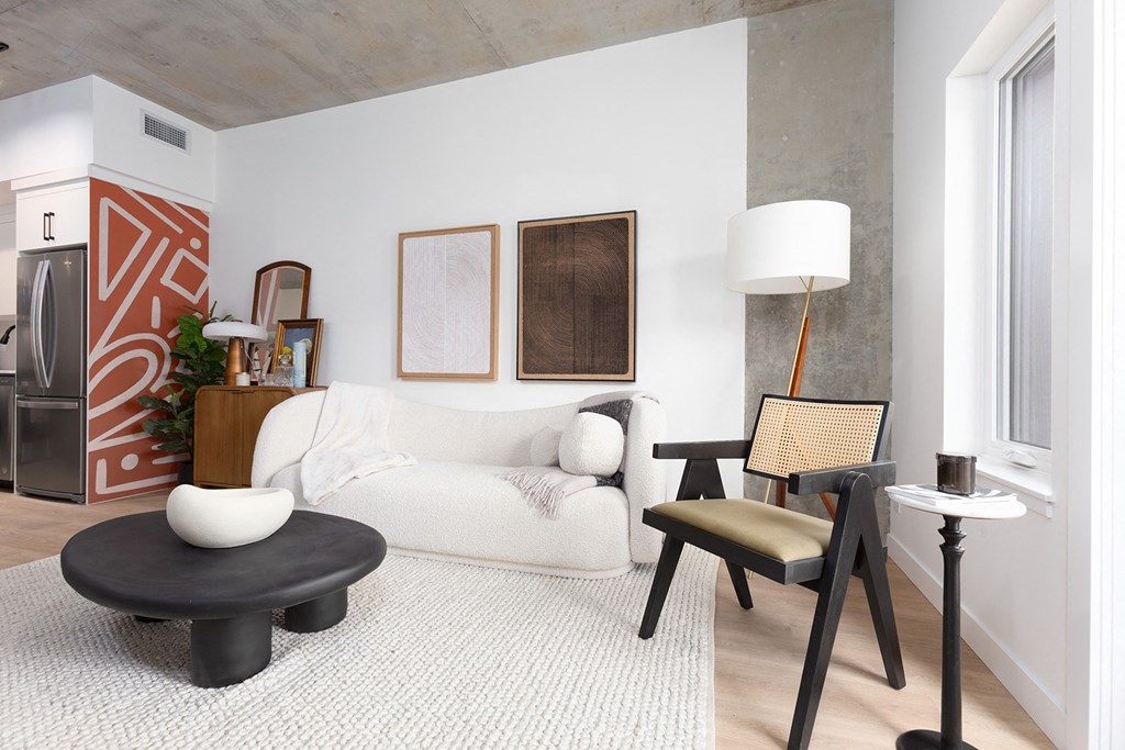 a living room with a white couch and chairs and a table
