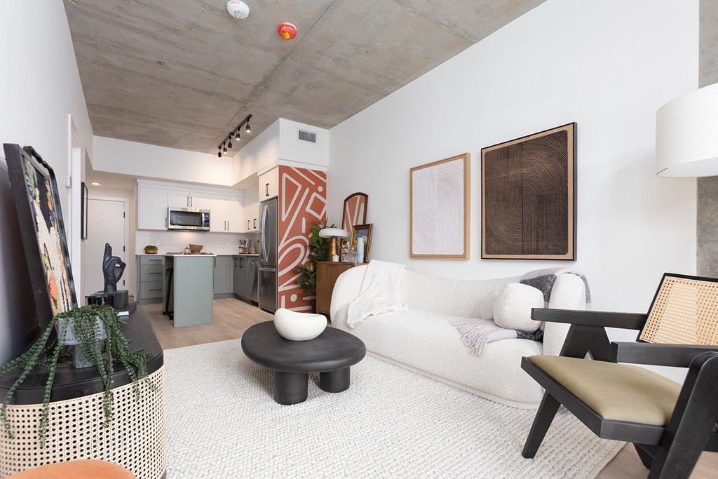 a living room with a white couch and a kitchen
