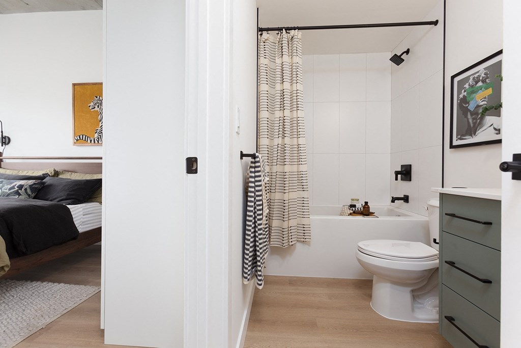 a small bathroom with a toilet and a shower and a bed