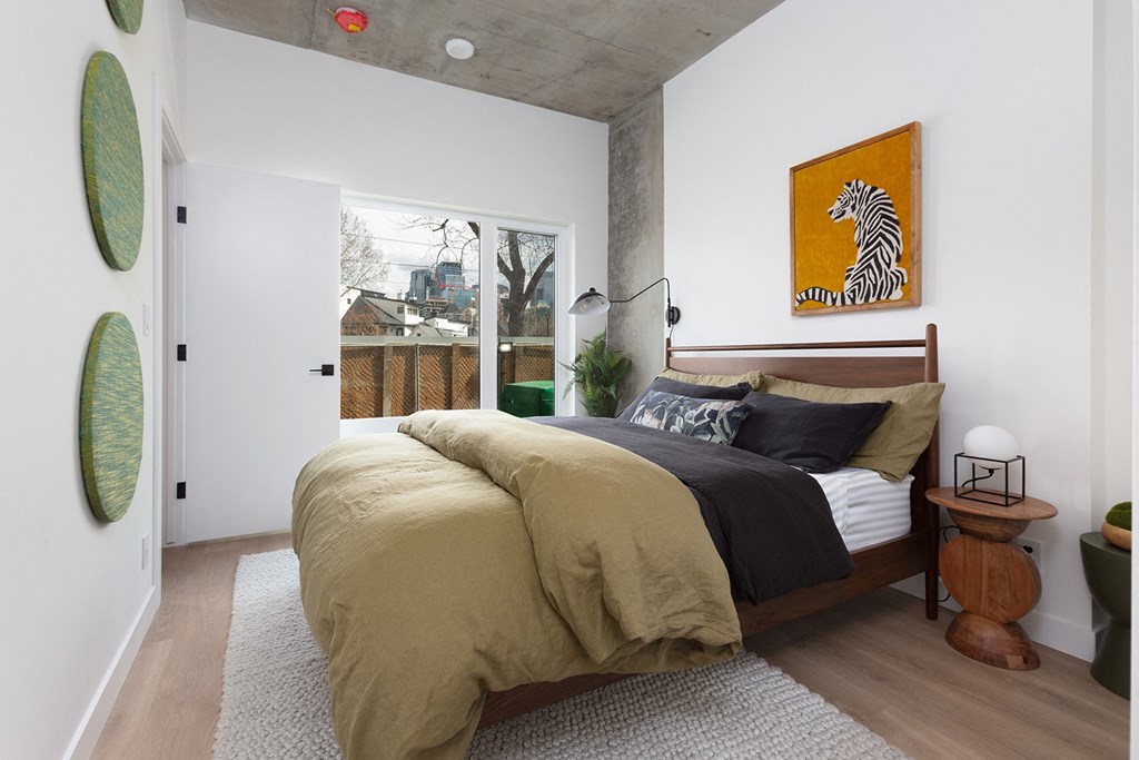 a bedroom with a bed and a large window