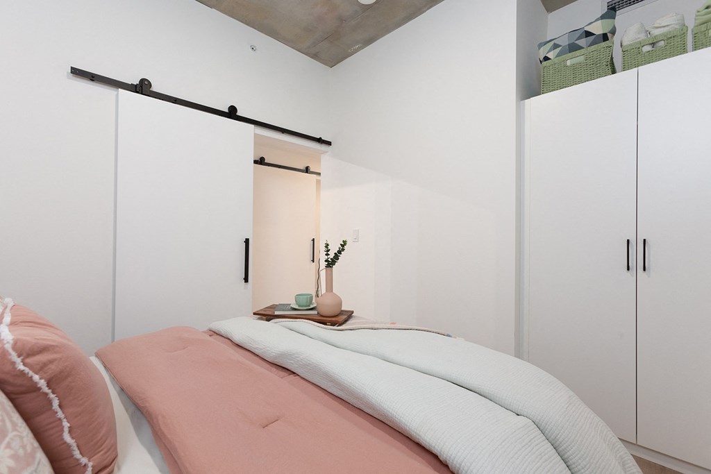 a bedroom with a bed and white closet doors