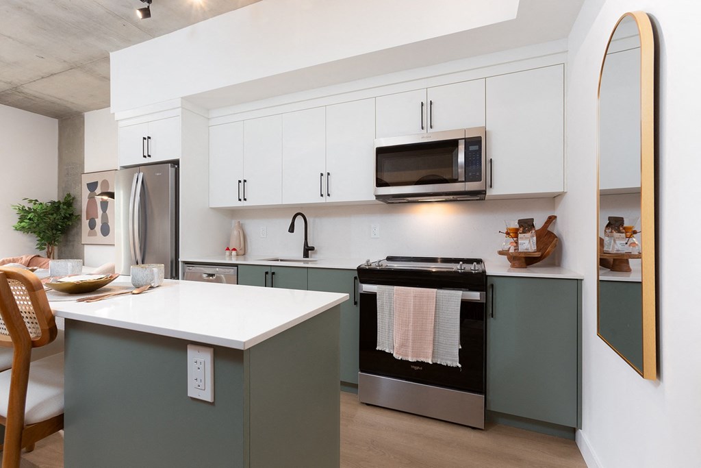 a kitchen with white cabinets and a stove and a microwave