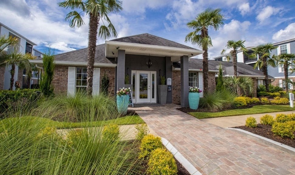 a house with palm trees and a walkway in front of it
