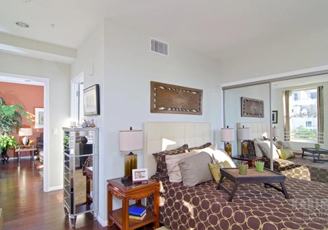A bedroom with a large bed and a wooden table.