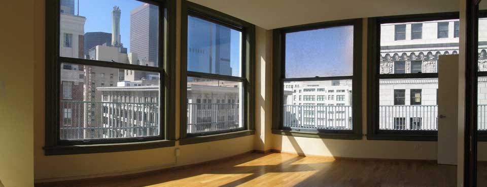 A room with a view of the city through large windows.