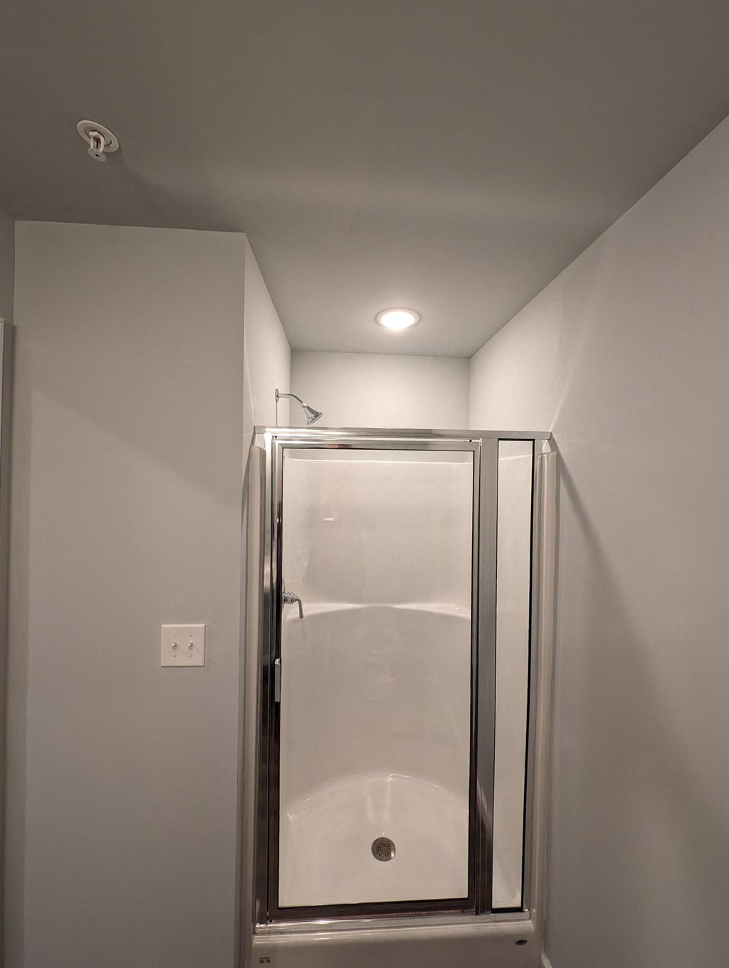 a shower in a small bathroom with a glass door